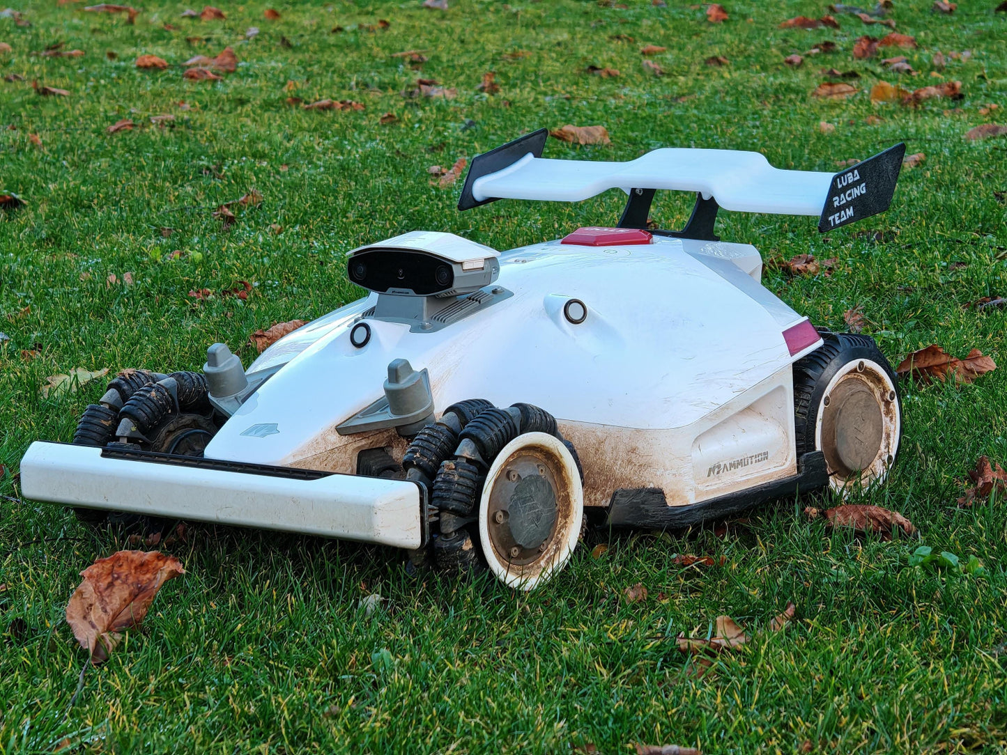 Robot tondeuse LUBA équipé de l’aileron racing sur pelouse, vue d’ensemble